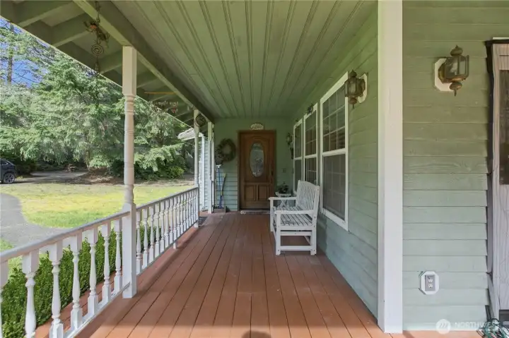 The covered front porch wraps seamlessly around to a two-tier deck in the rear, perfect for outdoor living and entertaining.