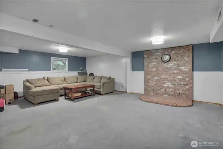 Spacious finished basement with a designated setup for a third woodstove.