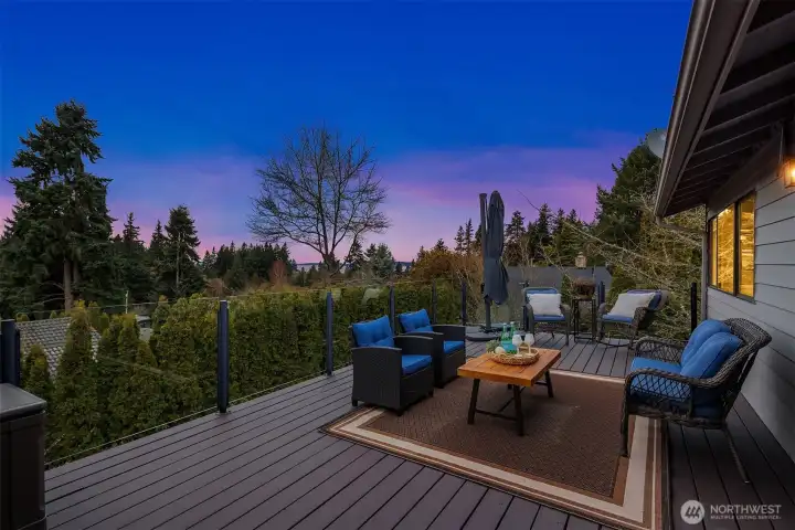 Sunset views from your private sanctuary. This expansive composite deck offers glass railings for an unobstructed view of the lush Pacific Northwest horizon.
