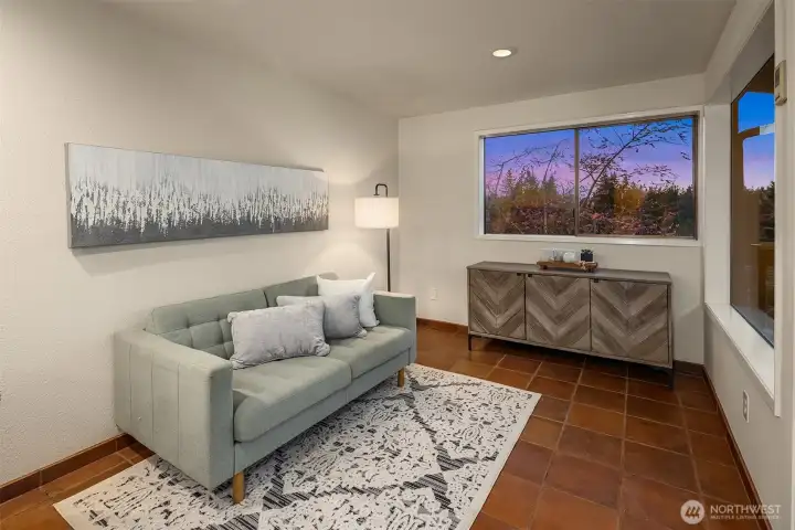This sun-drenched bonus nook just off the kitchen, with terra cotta tile flooring makes for an ideal reading corner, home office, or morning coffee retreat.