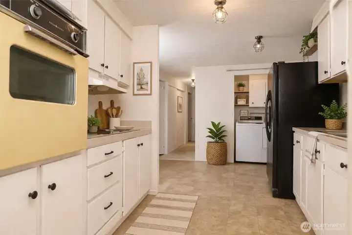 The kitchen features an electric stove, built-in oven, and ample cabinetry for generous storage and functionality.  VIRTUALLY STAGED