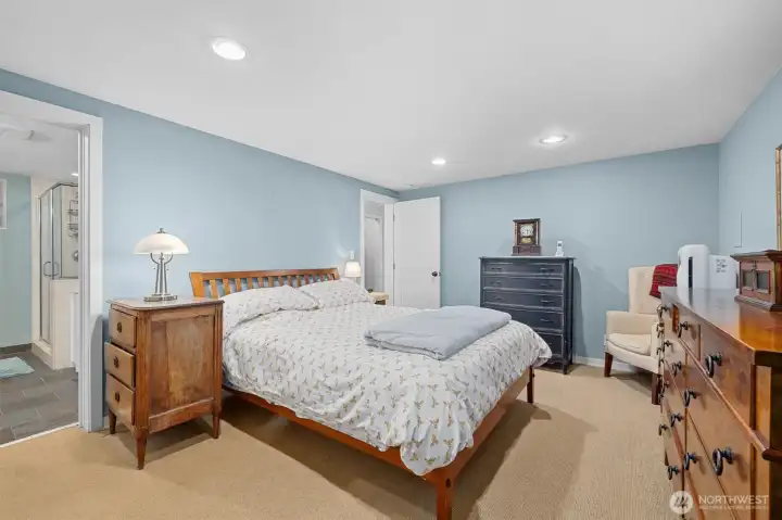 Primary bedroom on lower level. To the left is the full bath with tub and separate shower. Heated slate floors.