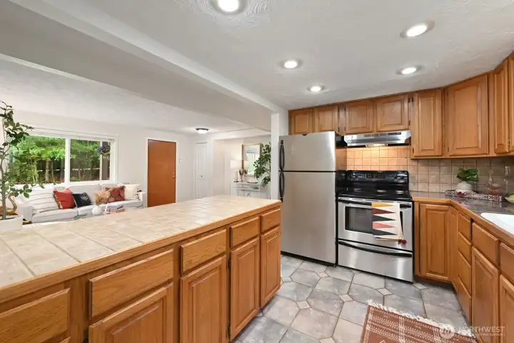 Newer SS appliances, abundant storage, and a desirable peninsula seamlessly connect the kitchen to the living area.