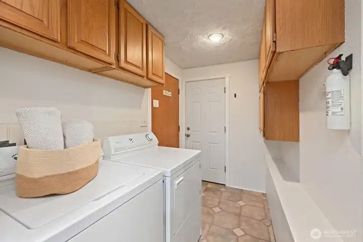 Laundry and additional storage, with access to the deck and entrance to the garage.