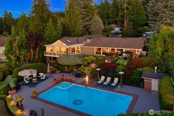 An evening glow sets the scene for poolside .gatherings, with the sunroom's warm light spilling out over the patio and gardens beyond. An evening glow sets the scene for poolside .gatherings, with the sunroom's warm light spilling out over the patio and gardens beyond.