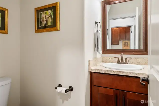 Powder room with vanity is located across from the laundry, right next to the garage. Easy access for a pit stop while you are tinkering with your tools in the garage.