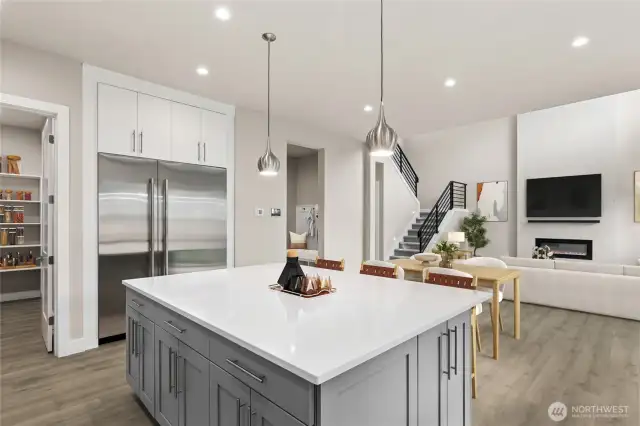 Stainless steel JennAir appliances with 36" built in refrigerator and 24" built in freezer column. Oversized slab quartz island and 6 burner gas range.