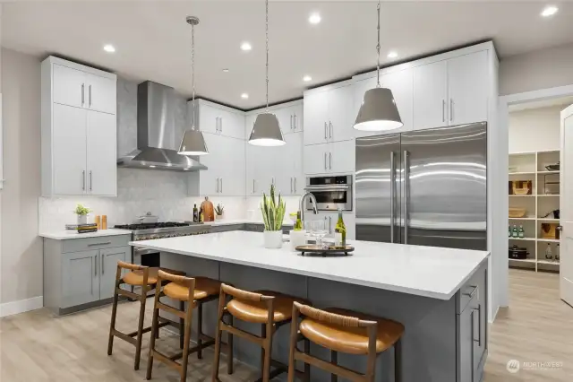 Another model showing similar color scheme. Finishes will vary.  Enjoy hosting in your chef's kitchen equipped with JennAir appliances including 36” built-in refrigerator + 24” built in freezer, 48” dual fuel gas professional range with griddle, wall-mounted hood, built-in microwave oven with speed-cook.