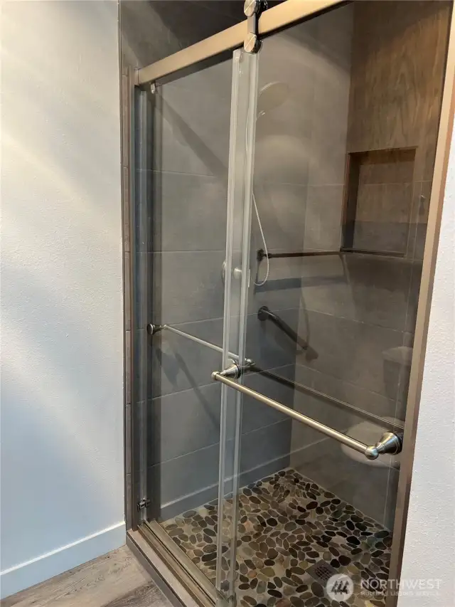 The 3/4 bath shower is beautifully updated and looks like a spa right off the primary bedroom