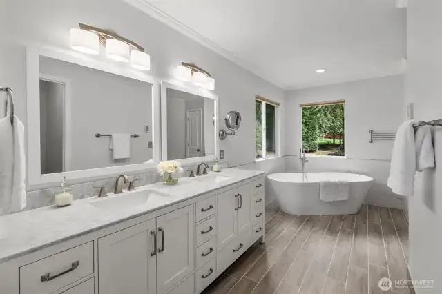 Modern bathroom has dual vanity and soaking tub.