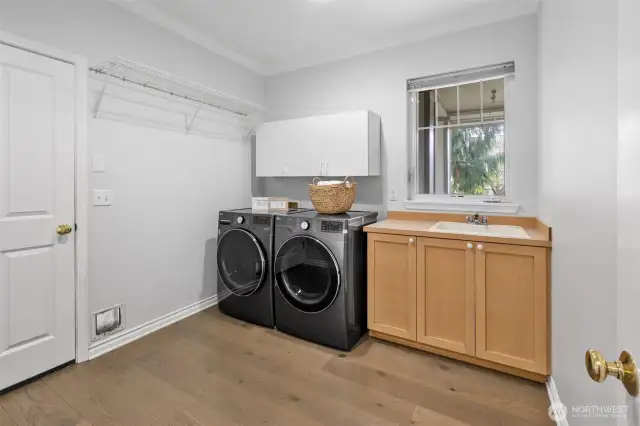 Spacious laundry room with utility sink and extra storage cabinets.  W/D stay with the home.