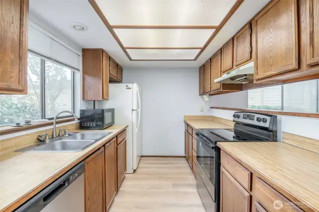New dishwasher, stove, sink, and flooring in the kitchen