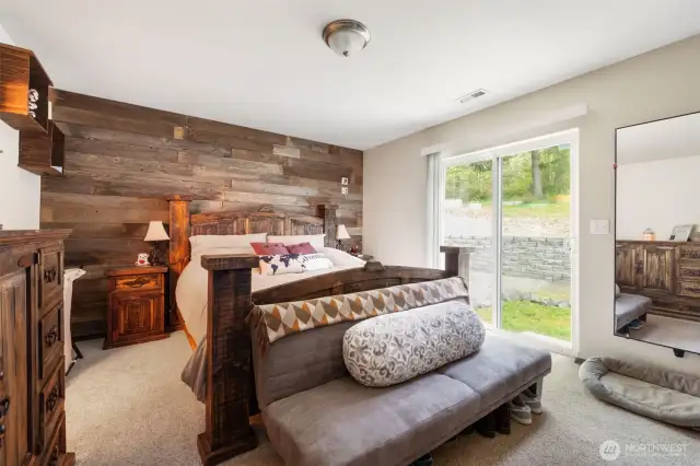 Nice accent wall behind the bed and a sliding glass door leading out to the yard.