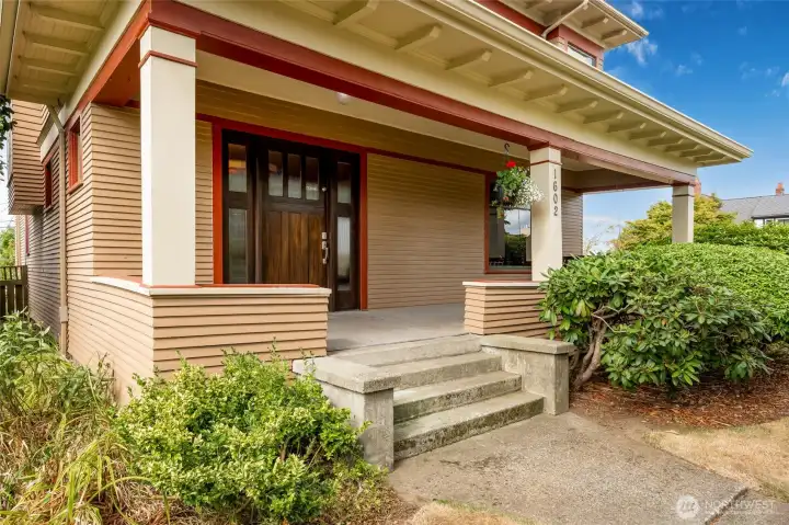 A large front porch with a deck swing leads to a Dutch front door.