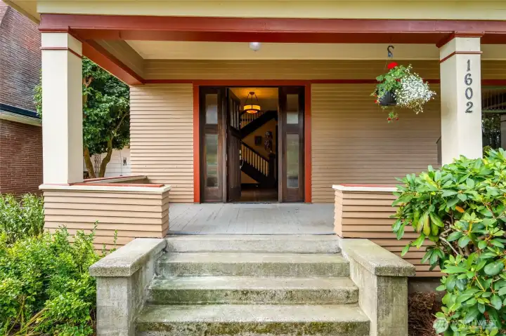 A large front porch with a deck swing leads to a Dutch front door.