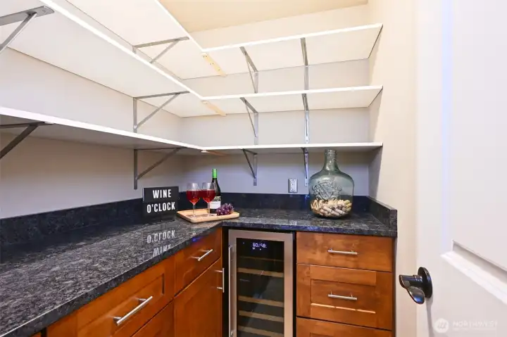 Butler's pantry with a wine fridge and lots of storage and counter space.