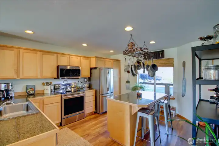 Large kitchen has stainless steel appliances.