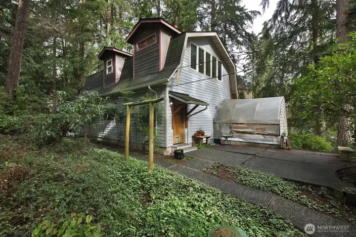 Main home. Greenhouse. Large patio space for outdoor entertaining.