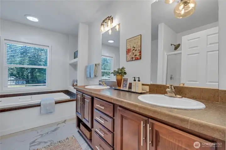 Primary bath with dual sinks, soaking tub, and separate shower.