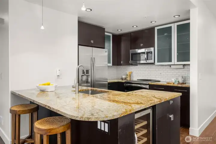 Remodeled chef's kitchen with granite countertops, soft-close cabinets, and bar seating.