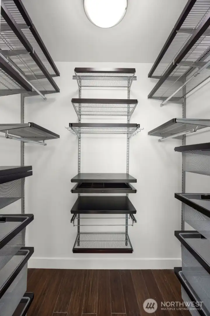 Large primary walk-in closet outfitted with custom storage organization.