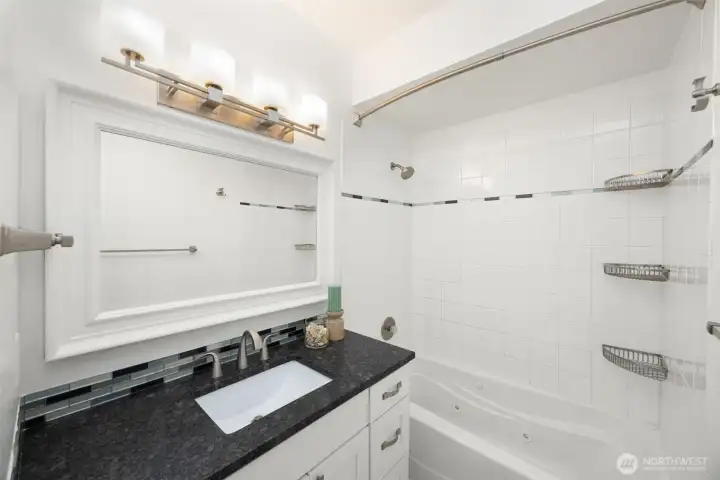 Full guest bathroom located next to the dedicated in-unit laundry closet.