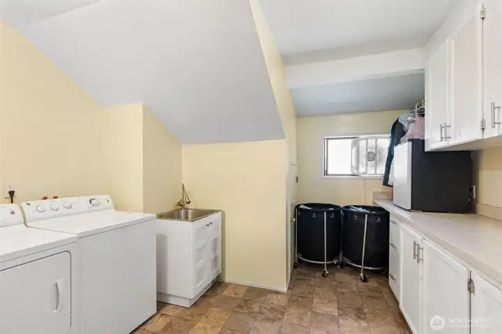 Full utility room with utility sink, cabinets, and counters. Full utility room with utility sink, cabinets, and counters.