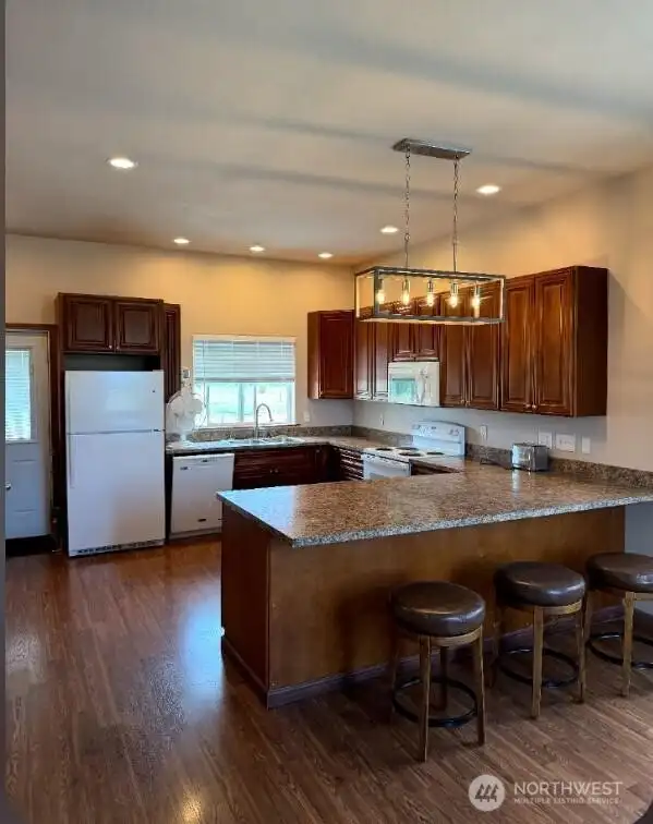 ADU Kitchen with door to back porch, breakfast bar and lots of beautiful storage.