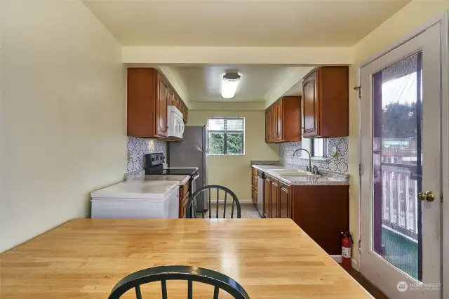 Kitchen with lots of cabinets and counterspace. Door to deck/balcony. White freezer conveys with property.