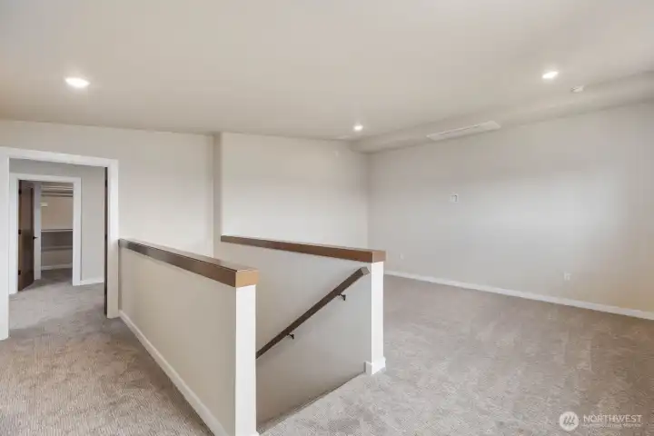 Upstairs landing with bonus room and access to private primary suite Upstairs landing with bonus room and access to private primary suite