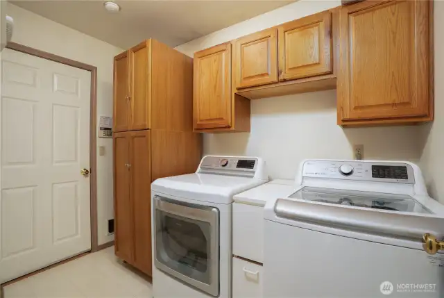 Off of the kitchen/great room area is your utility room and garage.  With lots of storage, your laundry room stays neat and tidy and bonus!  In the left hand cabinet is equipment for the surround sound stereo system in the great room.