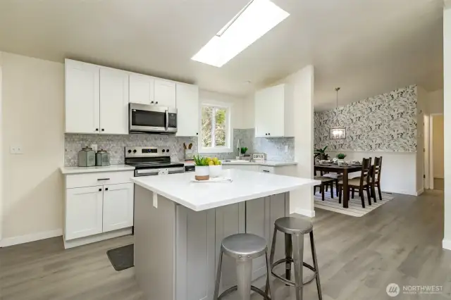 This is a fully new kitchen with breakfast bar, new cabinets, & new appliances.
