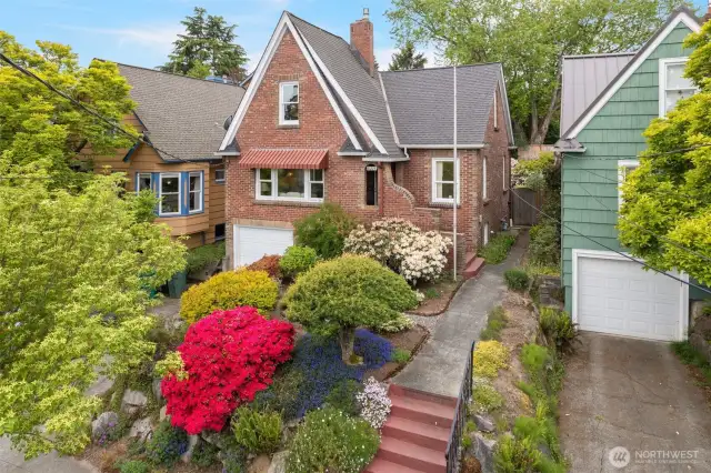 Pristine Green Lake Tudor w/Stately Curb Appeal, Primary Suite, & Enchanting Backyard Just Steps from Seattle's Most Popular Park. 1st time on the market since '36! Inviting, warm liv room w/adjacent din room AND upper level rec/media room (or convert to 4th bed). Uplifting kit leads to large deck bathed in serene sunsets. HIGH CEILING BASEMENT ALERT: Big rec room+bed+bath or ADU - bring your ideas! Captivating, secluded, lush backyard gardens w/pathways, privacy, full fencing, soothing beauty. Green Lake is a lifestyle: Duke's, Ben 'n' Jerry's, Retreat, play of ALL KINDS, & endless loops around the lake all year 'round! Convenient CENTRAL North Seattle near I-5, lightrail, EZ bike/bus commutes to SLU, UW, 520, Dwtn. Garage + off-strt spot.