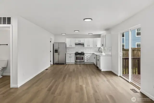 The updated kitchen, completed in 2021, features stainless steel appliances, sleek painted cabinetry, and elegant countertops.