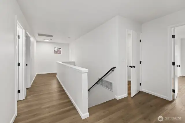 Welcome to the upper level! To the right, you'll find the door to the primary bedroom, with a spacious storage closet conveniently located next to the stairs.
