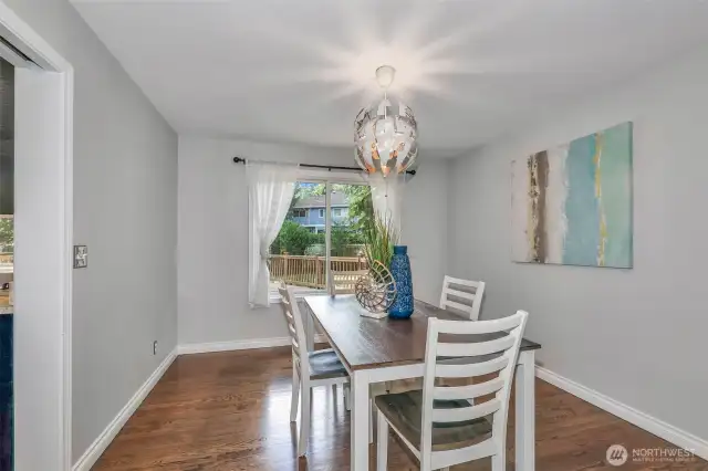 The formal dining room provides the perfect backdrop for hosting memorable meals. Hardwood flooring and natural light from the sliding glass door bring warmth and ease to everyday dining.