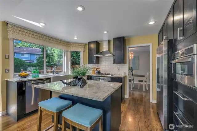 This thoughtfully designed kitchen blends form and function with gas cooking, tile backsplash, and rich cabinetry. A large corner window invites natural light and backyard views into your daily routine.