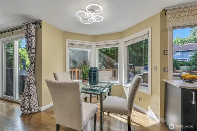 The casual dining nook offers a cozy space to enjoy morning coffee or casual meals, surrounded by windows that bring in garden views and warm natural light throughout the day.