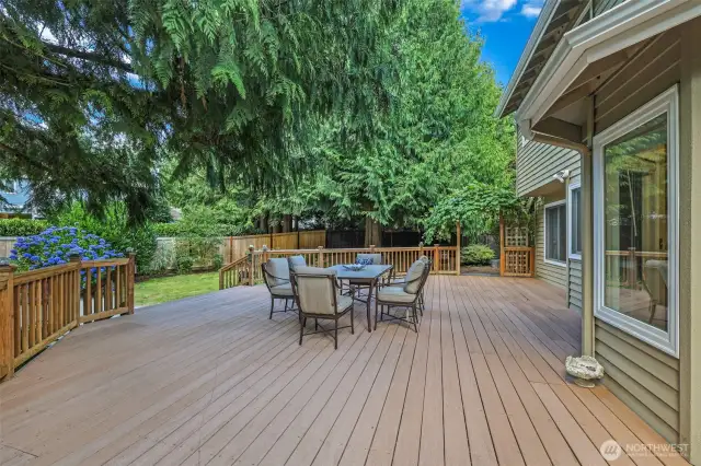 Step onto the expansive back deck—perfect for entertaining or relaxing in privacy. Surrounded by mature evergreens, this space blends seamlessly with the natural beauty of the oversized lot.