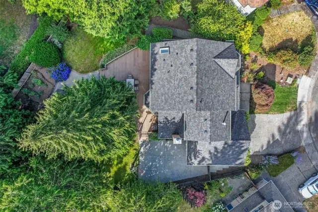 An aerial view showcases the home’s private lot and wraparound outdoor living spaces, as well as the newer roof (installed in 2024), giving buyers peace of mind.