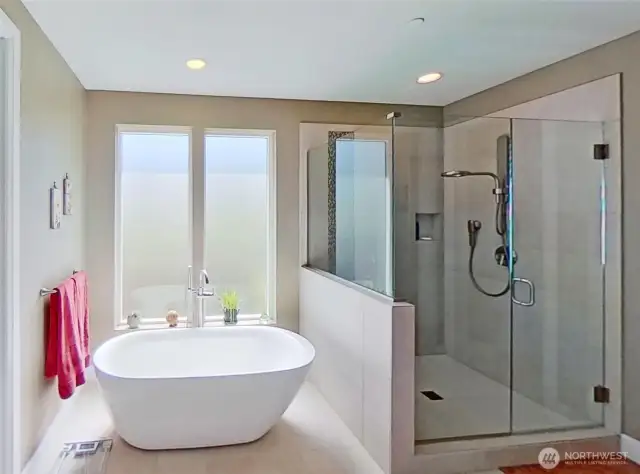 Primary bathroom with soaking tub and walk-in shower with glass surround