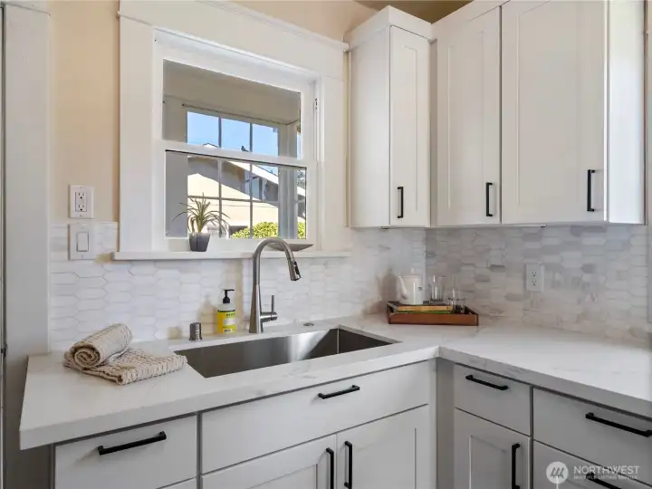 Quertz counter top and a large stainless steel sink.