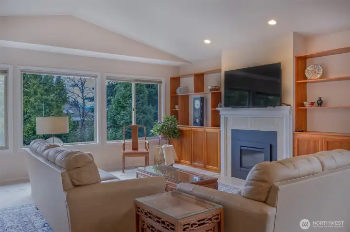 Living room with large windows-surrounded with natural greenery.