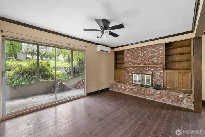Primary bedroom on the main floor with slider access to patio and a wood burning fireplace