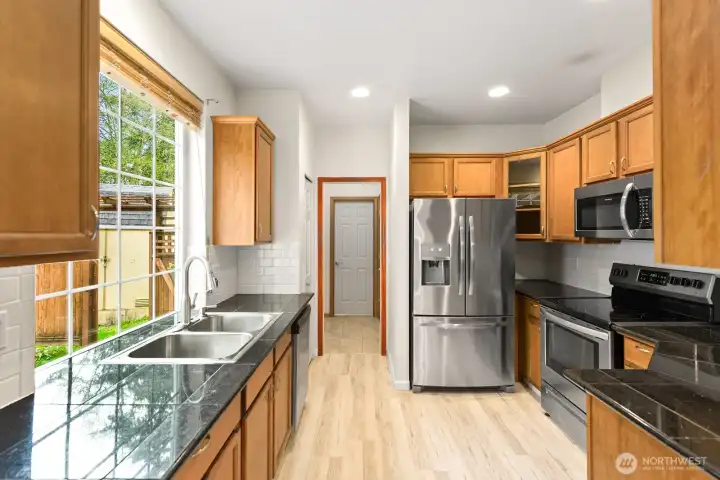 Picture window above kitchen sink that overloos backyard.