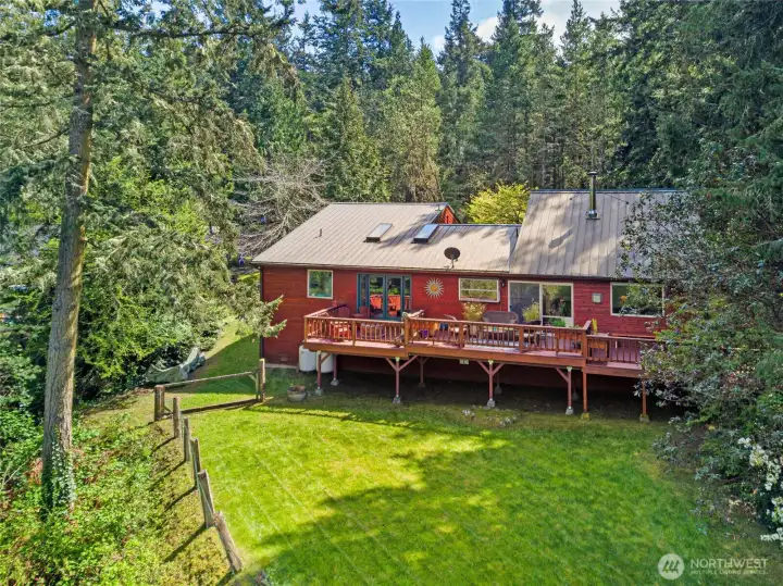 Private backyard retreat with level lawn, mature landscaping, and fenced space offers comfort, function, and room to enjoy island life.