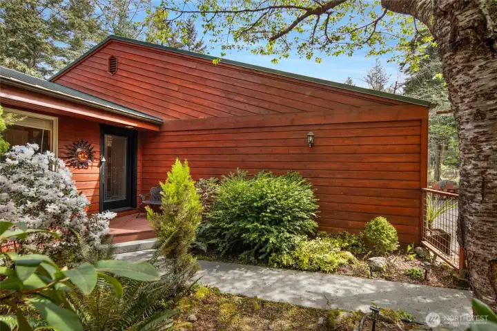 Charming fenced garden area offers a welcoming entry, mature landscaping, and peaceful spaces to enjoy the outdoors.