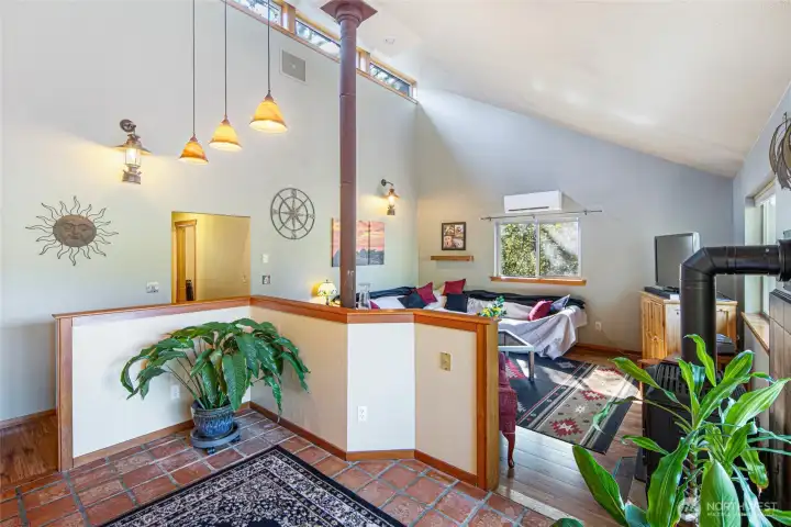 Dramatic vaulted ceilings and open living spaces create a warm, airy atmosphere centered around the double-sided fireplace and natural light.