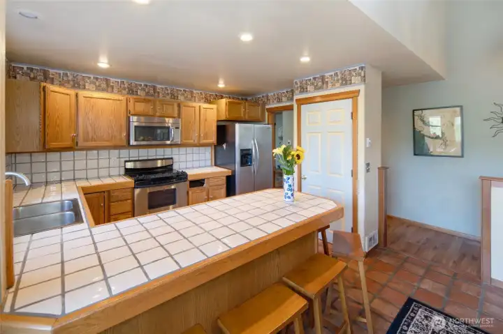 Spacious kitchen with ample cabinetry, breakfast bar seating, and an open layout connecting seamlessly to the main living areas.