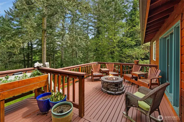 Expansive deck creates the perfect outdoor living space, complete with firepit seating, peaceful forest views, and room to relax or entertain year-round.